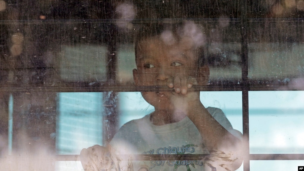 ARCHIVO - Un niÃ±o inmigrante mira desde un autobÃºs de la Patrulla Fronteriza de EE.UU. que sale del Centro de Procesamiento Central de la Patrulla Fronteriza de EE.UU. En McAllen, Texas, el 23 de junio de 2018.
