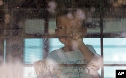 FILE - An immigrant child looks out from a U.S. Border Patrol bus leaving the U.S. Border Patrol Central Processing Center in McAllen, Texas, June 23, 2018.