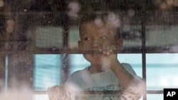 FILE - An immigrant child looks out from a U.S. Border Patrol bus leaving the U.S. Border Patrol Central Processing Center in McAllen, Texas, June 23, 2018. 