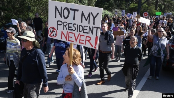 FILE - A woman holds a sign during a protest against President-elect Donald Trump at Golden Gate Park in San Francisco, California, Nov. 13, 2016.