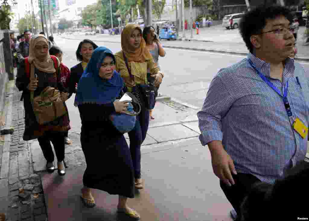 Indonesian workers run as they are evacuated from their offices at Thamrin business district in Jakarta.