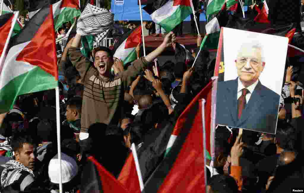 A Palestinian man cheers near a placard depicting President Mahmoud Abbas during a rally marking the U.N. General Assembly's upgrading of the Palestinians' status from "observer entity" to "non-member state", in the West Bank city of Ramallah December 2.