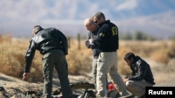 Investigators from the National Transportation Safety Board (NTSB) look at wreckage from the crash of Virgin Galactic's SpaceShipTwo near Cantil, California, Nov. 2, 2014. 