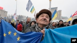 FILE - A pro-European Union activist with Ukrainian and European Union flags rallies with others in Independence Square in Kyiv, Ukraine, Dec. 20, 2013. The protests ended up toppling Ukraine's Russia-backed president Viktor Yanukovych.