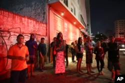 Neighborhood residents watch firefighters working in the the rubble of a building that caught fire and collapsed in Sao Paulo, Brazil, May 1, 2018.
