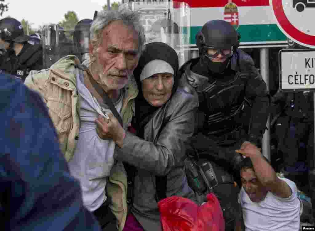 Hungarian riot police fight migrants at the border crossing with Serbia in Roszke. Police fired tear gas and water cannons at protesting migrants demanding they be allowed to enter from Serbia on the second day of a border crackdown.