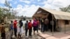 FILE - People stand in line to receive a COVID-19 vaccine, at the Narok County Referral Hospital, in Narok, Kenya, Dec. 1, 2021. 
