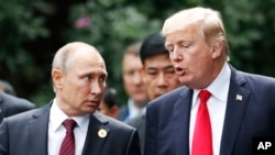 FILE - U.S. President Donald Trump and Russia's President Vladimir Putin talk during a photo session at the APEC Summit in Danang, Vietnam, Nov. 11, 2017. 