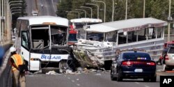 FILE - In this Sept. 24, 2015, file photo, a "Ride the Ducks" amphibious tour bus, right, and a charter bus remain at the scene of a fatal collision on the Aurora Bridge in Seattle.
