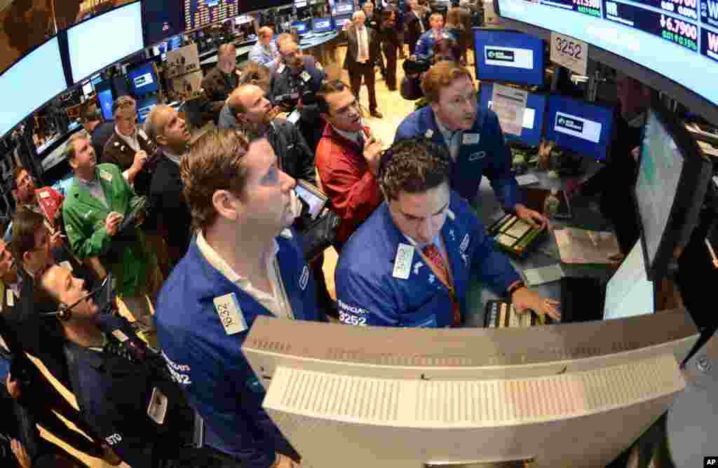 On Nov. 8, 2012, file photo, Gregg Maloney, left, and Ronnie Howard, center, both of Barclays, direct trading on the floor of the New York Stock Exchange, in New York U.S. stocks eked out the tiniest of gains on Monday Nov. 12, 2012, small comfort after worries about the fiscal cliff sent the market plunging last week. (AP Photo/Henny Ray Abrams)