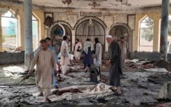 昆都士一座什叶派清真寺遭到自杀炸弹袭击后，人们在寺内查看现场。(2021年10月8日)