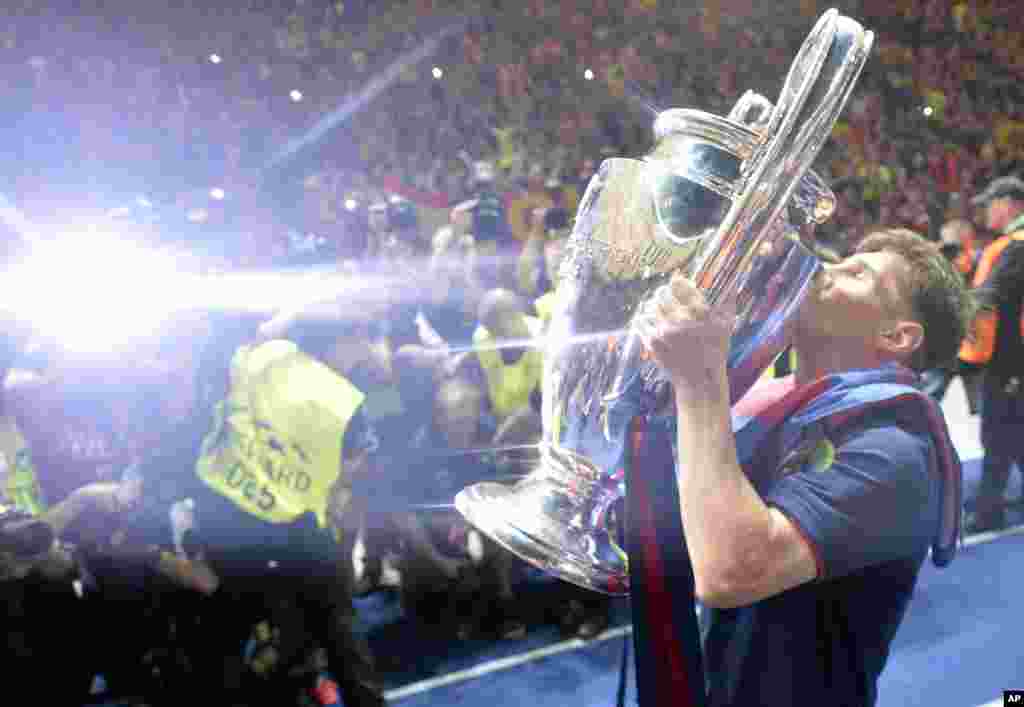 Lionel Messi embrasse le trophée après la victoire 3-1 de son équipe, FC Barcelone, contre la Juventus de Turin en match de finale de Champions League au stade olympique de Berlin, 6 juin 2015.