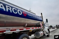 FILE - An Arco tanker truck drives south along Interstate 5 in Los Angeles, May 10, 2018. Prices at the pump have increased about 31 cents to near $3 per gallon since January.