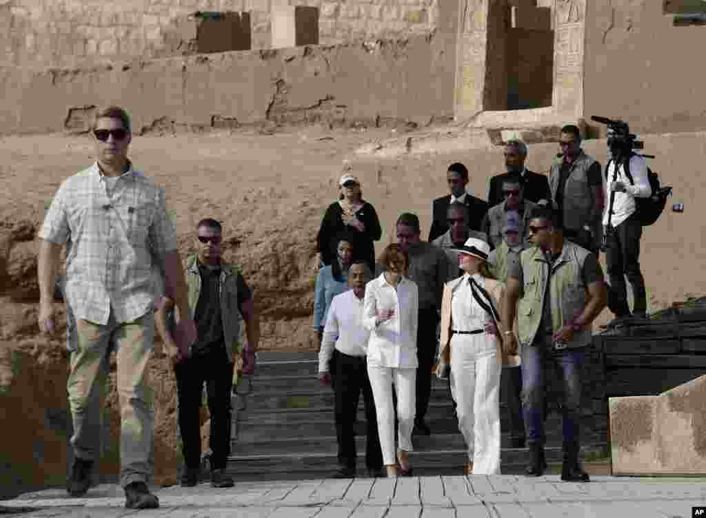 First lady Melania Trump, center arrives at the ancient statue of Sphinx, with the body of a lion and a human head, at the historic site of the Giza Pyramids, in Egypt, Oct. 6, 2018. 