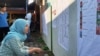 FILE - Seorang pemilih memeriksa daftar legislatif yang dipasang di sebuah TPS di Sleman, DIY dalam Pemilu 2019. (Foto: VOA/ Nurhadi)
