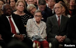 U.S. Supreme Court Associate Justices, from left, Clarence Thomas, Ruth Bader Ginsburg and Stephen Breyer watch from the front row as Brett Kavanaugh takes his ceremonial oath of office while participating in a ceremonial public swearing-in in the East Room of the White House in Washington, Oct. 8, 2018.
