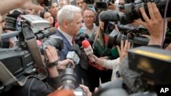 FILE - The leader of Romania's ruling Social Democratic party, Liviu Dragnea, is surrounded by media as he arrives at the anti-corruption prosecutors' office, in Bucharest, Romania, April 27, 2018. 