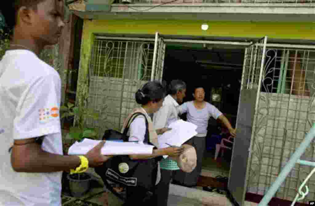 A Myanmar census enumerator and volunteers enter a house to collect information in Yangon, Myanmar, Sunday, Mar 30, 2014. Enumerators fanned out across Myanmar on Sunday for a census that has been widely criticized for stoking religious and ethnic tension