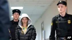 Anastasia Vashukevich, also known on social media as Nastya Rybka, center, is escorted in the court room in Moscow, Russia, Jan. 19, 2019.