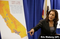 In this March 24, 2016 photo, then-California Attorney General Kamala Harris points to an image showing the location of Corinthian Colleges located in California during a news conference in San Francisco.