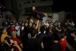 A Palestinian groom is thrown in the air during a wedding party in Azmut near the West Bank city of Nablus, Thursday, Sept. 24, 2020. In a region where marriage is the cornerstone of society, couples are plowing ahead with weddings, despite the deadly risks. From the Palestinian territories to the United Arab Emirates, officials attribute a spike in coronavirus cases to traditional, large-scale weddings that flout public health restrictions. (AP Photo/Majdi Mohammed)