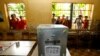 柬埔寨上届大选期间，一些年轻人在首都金边一处投票站对着投票箱拍照(2013年7月28日)