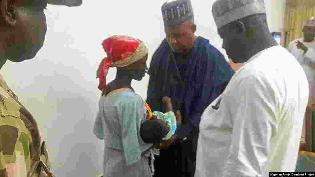 Rescued Chibok school girl, Amina Ali and her baby speak with officials in Maiduguri.