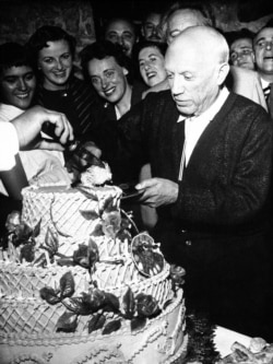 Pablo Picasso, famed Spanish painter, accepts first piece of 67-pound birthday cake as he celebrates his 75th birthday, with a birthday party at Vallauris in southern France on Oct. 24, 1956.