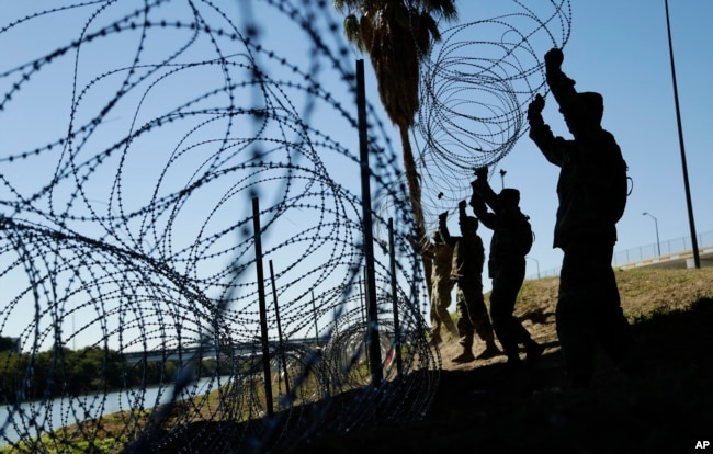 Members of the U.S. military install multiple tiers of concertina wire along the banks of the Rio Grande near the Juarez-Lincoln Bridge at the U.S.-Mexico border, Nov. 16, 2018, in Laredo, Texas.