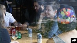 Diana Downard, 26, has drinks with friends at a pub in Denver, July 6, 2016. 