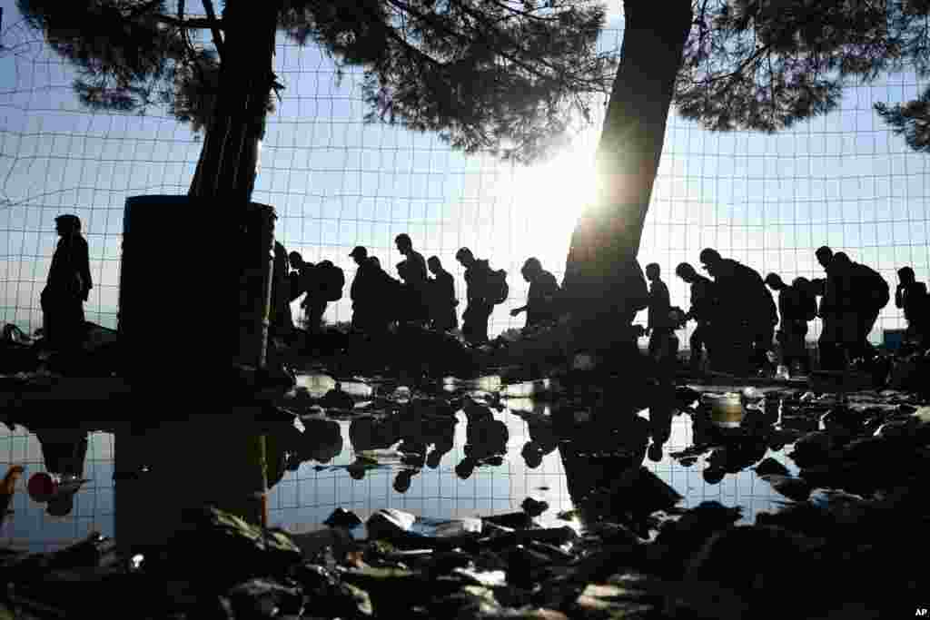 The sun rises as refugees and migrants walk to pass from the northern Greek village of Idomeni to southern Macedonia, Sept. 11, 2015. The sudden onset of autumn has taken tens of thousands by surprise all along the Balkans route from Greece to Hungary.