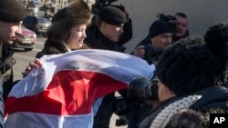Офицеры белорусской полиции задерживают женщину, развернувшую прежний флаг Беларуси. Минск, Беларусь. 25 марта 2018 г.