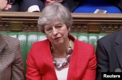 FILE - British Prime Minister Theresa May reacts after tellers announced the results of the vote Brexit deal in Parliament in London, Britain, March 12, 2019, in this screen grab taken from video.
