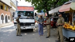 Sri Lankan police officers perform a security check on a truck at a roadside in Colombo, Sri Lanka, April 25, 2019.