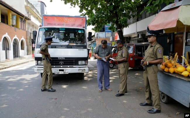 Sri Lankan police officers perform a security check on a truck at a roadside in Colombo, Sri Lanka, April 25, 2019.