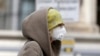 Seorang perempuan meggunan masker di Wina, Austria, 30 Maret 2020. (Foto: AP)