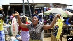 A woman holds bags of rice at a market in Abidjan on April 14, 2011