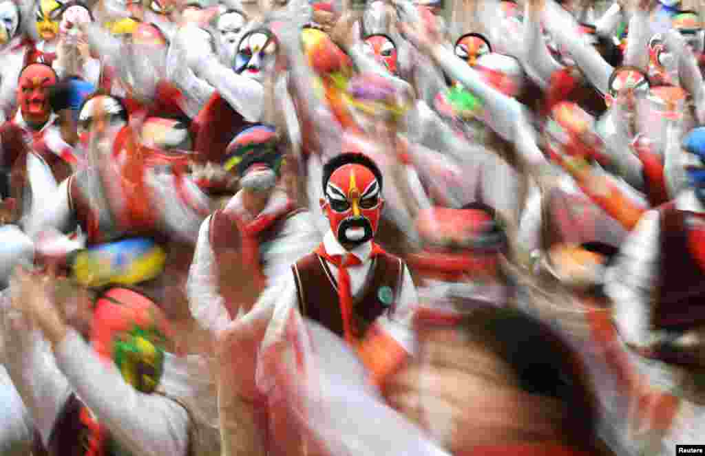 Students wearing traditional opera masks attend an exercise session in Wuhan, Hubei province, China.