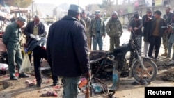 An Afghan police officer stands at the site of a suicide blast in Faryab, northern Afghanistan, March 18, 2014.