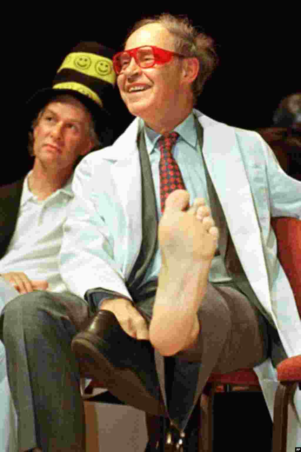 Nobel Laureate Dudley Herschbach (Chemistry '86) shows off his left foot as a plaster cast of it was auctioned off during the Seventh First Annual Ig Nobel Award ceremonies at Harvard University in Cambridge, Massachusetts, October 9. Herschbach, Richard