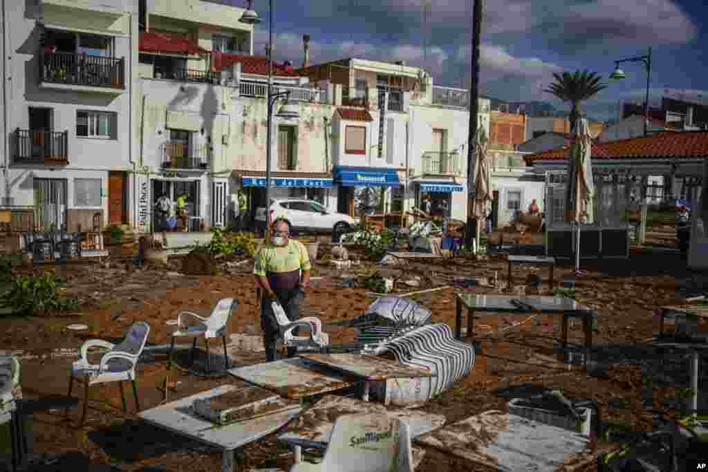 A municipality worker cleans up after flooding in a seaside town of Alcanar, in northeastern Spain.