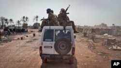 FILE - South Sudanese government forces ride on a vehicle through a still-smoldering town in Unity State, South Sudan, Jan 12, 2014. The leader of the National Salvation Front said the government is to blame for initiating current fighting in Yei River State.