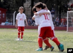 Candelaria Cabrera watches her soccer teammates celebrate a goal against Alumni in Chabaz, Argentina. "Cande,” as she is known by friends and family, is the only girl playing in a children's soccer league in the southern part of Argentina's Santa Fe province, birthplace of stars including Lionel Messi, Gabriel Batistuta and Jorge Valdano.