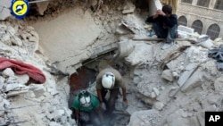 ພະນັກງານໜ່ວຍປ້ອງກັນພົນລະເຮືອນ ໝວກເຫລັກຂາວ ຂຸດຫາຊາກສົບ ແລະພວກທີ່ລອດຊີວິດມາໄດ້ ຕາມຊາກຫັກພັງ ທີ່ຄຸ້ມ Bustan al-Basha ຂອງເມືອງ Aleppo.