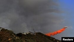 Un avión super tanque DC-10 vuela sobre las montañas San Gabriel en el bosque Angeles National, tratando de controlar los incendios forestales desatados desde el domingo 2 de septiembre.