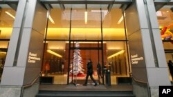 People enter the Russell Investments Center building Monday, Dec. 7, 2015, in Seattle. Over 100 people have gotten sick in a norovirus outbreak at the office building, health officials reported Monday.