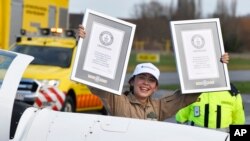 Belgium British teenage pilot Zara Rutherford holds up her certificates after landing her Shark ultralight plane at the Kortrijk airport in Kortrijk, Belgium, Jan. 20, 2022. 