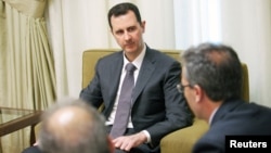 Syria's President Bashar al-Assad (C) is seen during an interview with the al-Thawra newspaper in Damascus in this handout photograph distributed by Syria's national news agency SANA, July 3, 2013