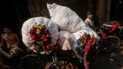 A man is transporting unused leftover fabric from factories at a market in New Delhi, India, November 4, 2021. The fabric will be repurposed to create high-end sustainable clothes. (REUTERS/Adnan Abidi)