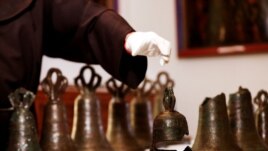 Father Stephane, Franciscan Friar and Liturgist of the Custody of the Holy Land reaches for the remains of a bell, part of a collection from the 12th century. (Reuters)